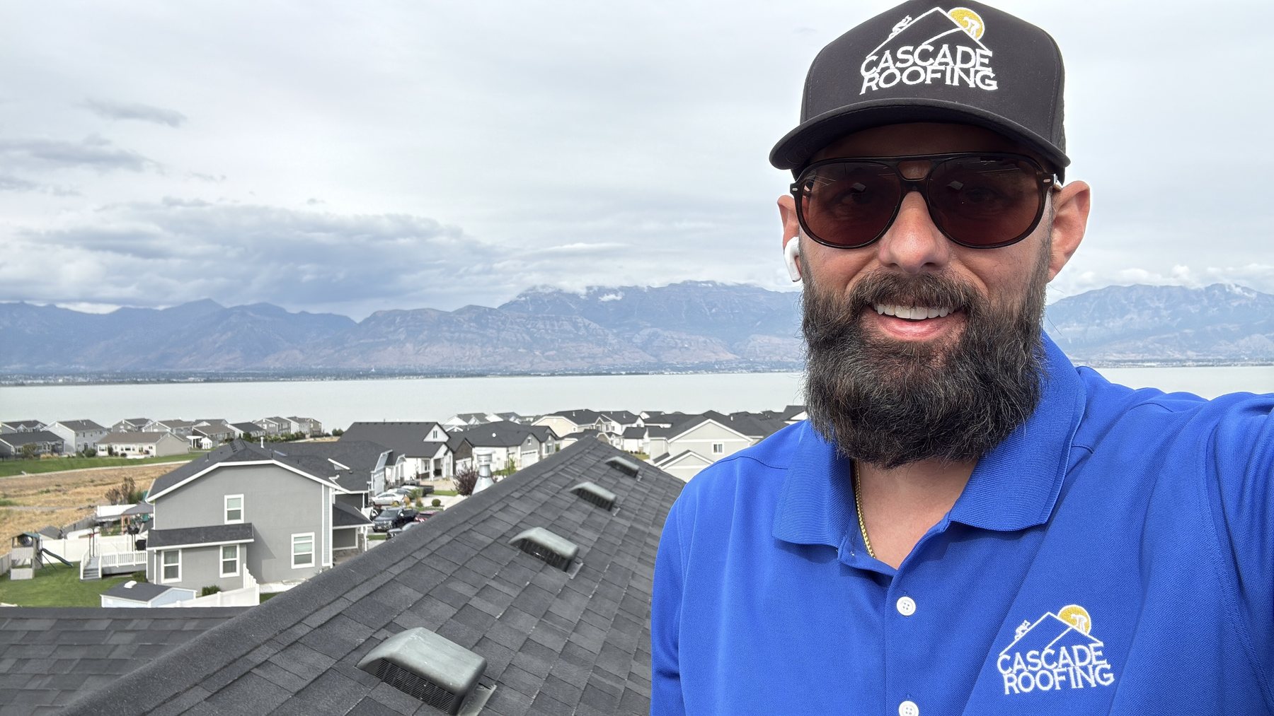 A Cascade Roofing estimator on a roof above Utah Lake